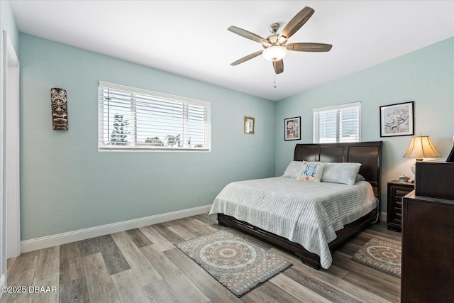 bedroom featuring ceiling fan, baseboards, and wood finished floors