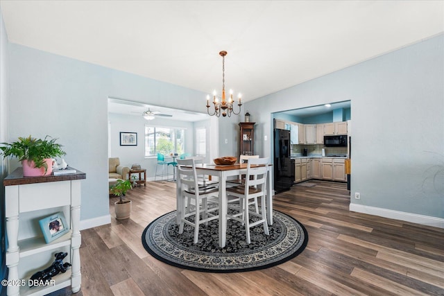 dining area with ceiling fan with notable chandelier, dark wood-type flooring, and baseboards