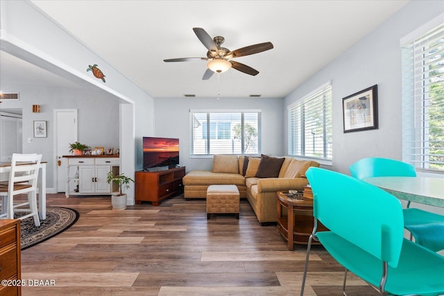 living area featuring a ceiling fan, visible vents, and wood finished floors