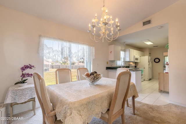 dining space with lofted ceiling, sink, light tile patterned floors, and a notable chandelier