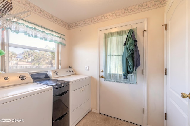 laundry area with washer and clothes dryer and light colored carpet