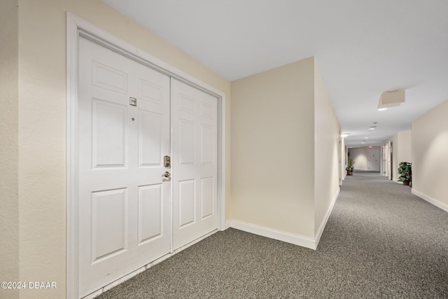 corridor featuring dark colored carpet