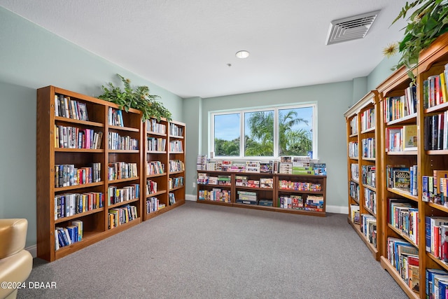 2 Oceans W Blvd Unit 707, Daytona Beach, FL 32118 - sitting room featuring bookshelves, carpet floors, and baseboards