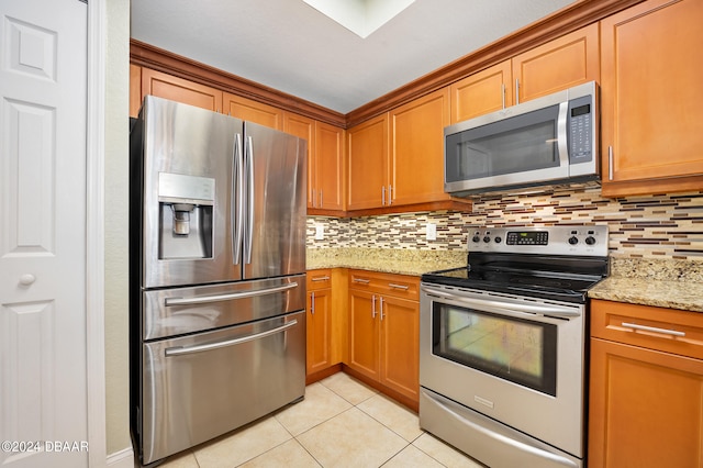 kitchen featuring light stone counters, tasteful backsplash, light tile patterned flooring, and appliances with stainless steel finishes