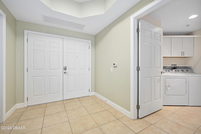 clothes washing area featuring cabinets, light tile patterned floors, and independent washer and dryer