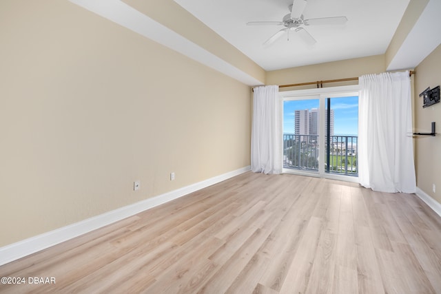 empty room with ceiling fan and light hardwood / wood-style floors