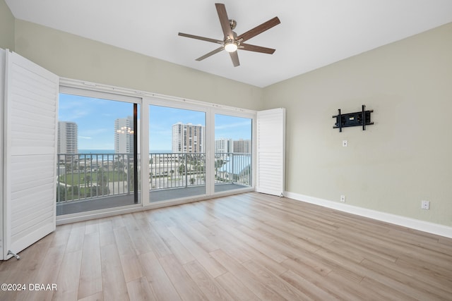 spare room with ceiling fan and light wood-type flooring