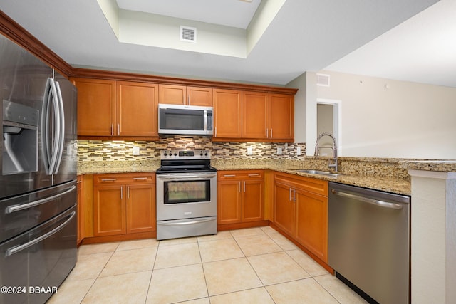 2 Oceans W Blvd Unit 707, Daytona Beach, FL 32118 - kitchen with stainless steel appliances, a sink, a raised ceiling, backsplash, and light tile patterned floors