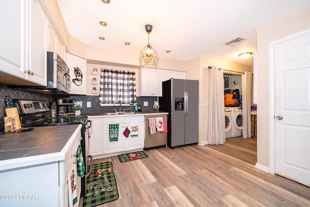 kitchen featuring tasteful backsplash, stainless steel appliances, decorative light fixtures, washing machine and clothes dryer, and white cabinetry