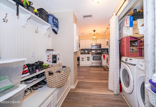 laundry room with wood-type flooring and separate washer and dryer