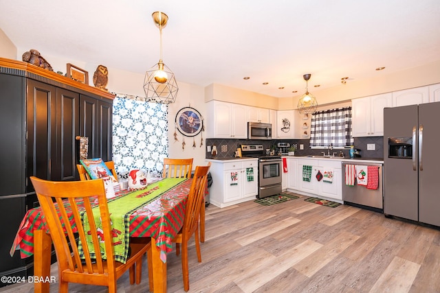 kitchen with white cabinets, stainless steel appliances, and decorative light fixtures