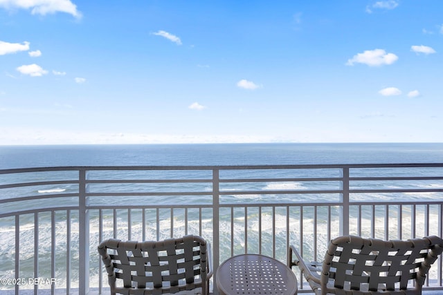 balcony featuring a view of the beach and a water view