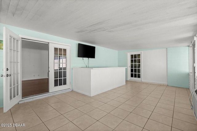 empty room with light tile patterned floors and french doors