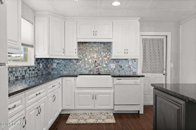 kitchen featuring sink, dark stone countertops, white cabinets, and white dishwasher