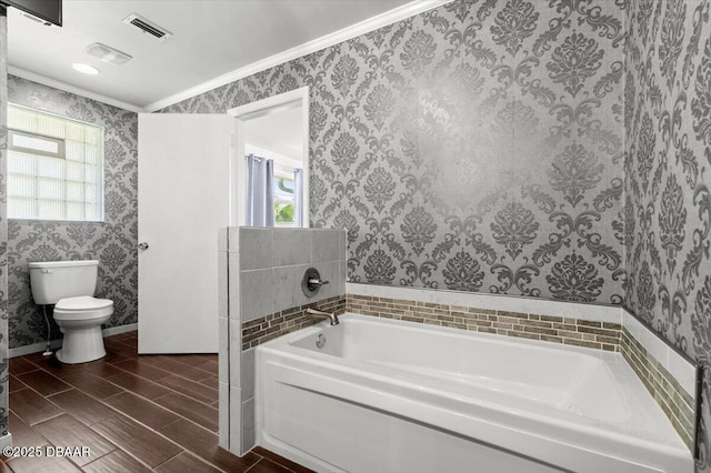 bathroom featuring ornamental molding, a bathtub, and toilet