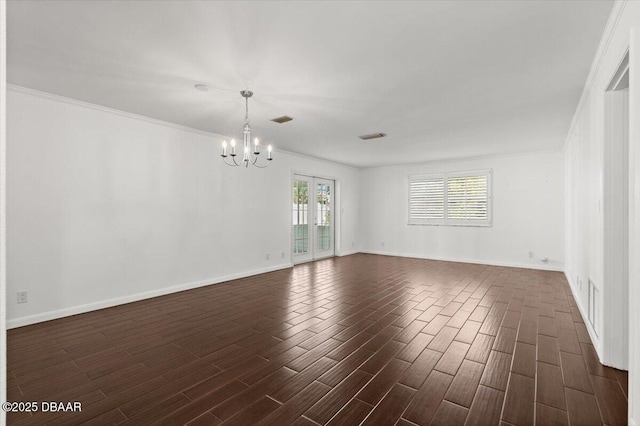 empty room featuring an inviting chandelier, ornamental molding, and dark hardwood / wood-style flooring