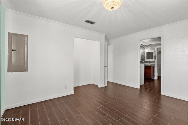 empty room featuring crown molding, dark hardwood / wood-style flooring, electric panel, and a textured ceiling