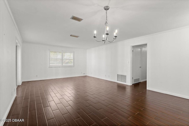 spare room featuring a notable chandelier, ornamental molding, and dark hardwood / wood-style floors