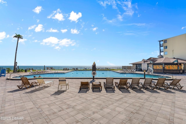 view of pool featuring a patio and a water view