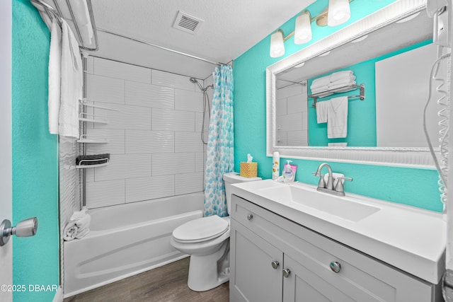 full bathroom featuring hardwood / wood-style floors, vanity, a textured ceiling, toilet, and shower / bath combo with shower curtain