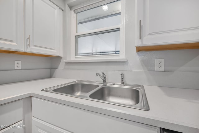 kitchen featuring sink and white cabinets