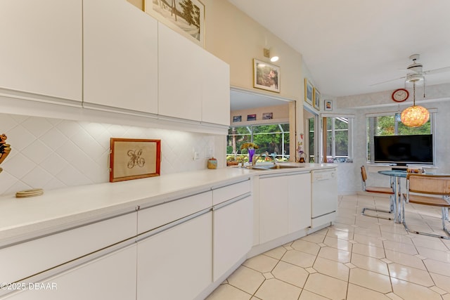 67 Kingsley Ln, Ormond Beach, FL 32174 - kitchen with white dishwasher, light countertops, white cabinetry, a sink, and backsplash