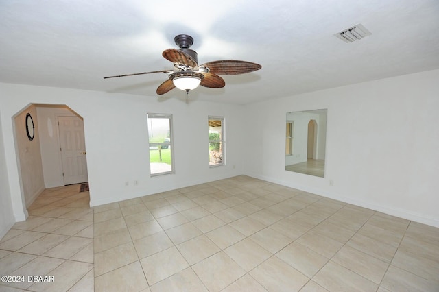 tiled spare room featuring ceiling fan