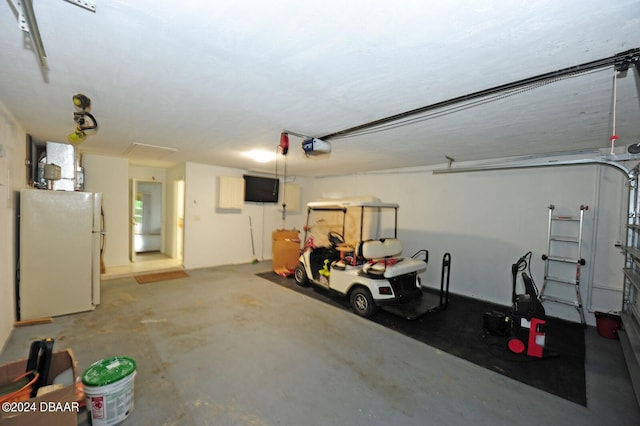 garage featuring a garage door opener and white fridge