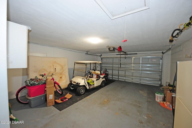 garage featuring white refrigerator and a garage door opener