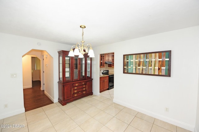 unfurnished dining area with a notable chandelier and light tile patterned floors