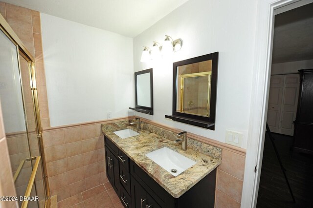 1889 Seclusion Dr, Port Orange, FL 32128 - full bath featuring tile walls, double vanity, a wainscoted wall, a tile shower, and tile patterned flooring