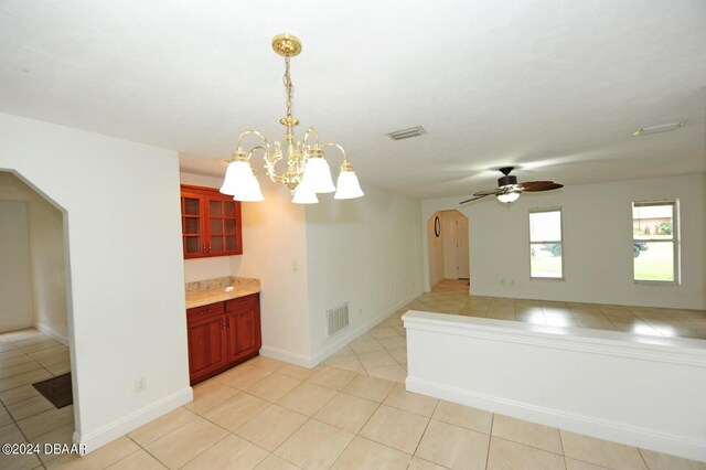 kitchen featuring pendant lighting, light tile patterned floors, and ceiling fan with notable chandelier