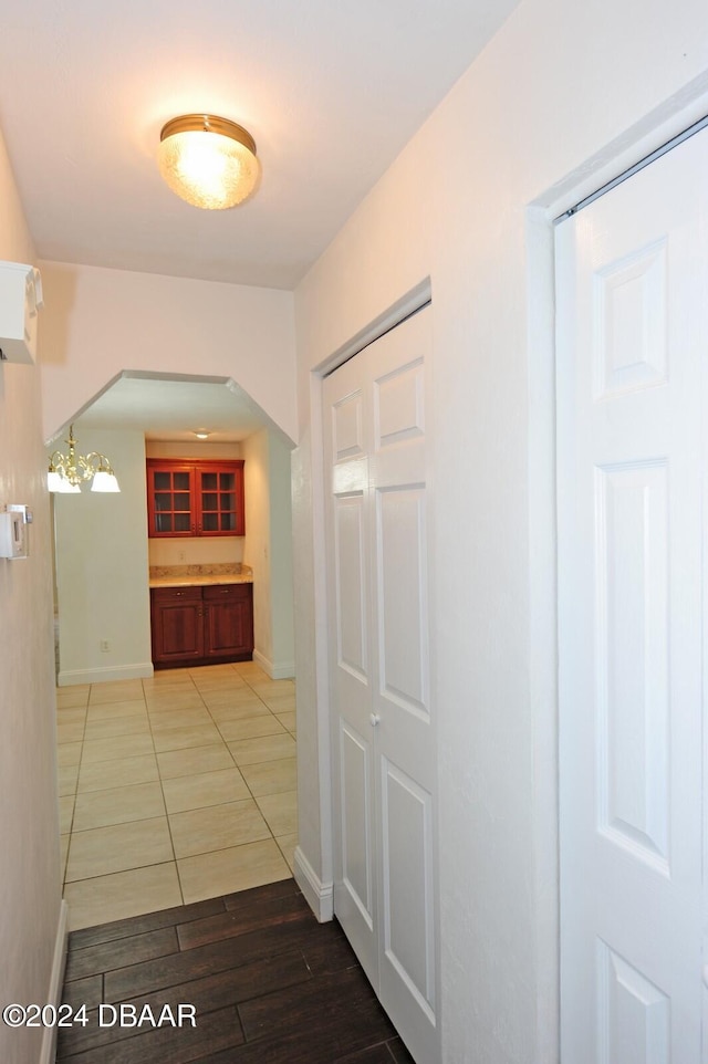 hallway featuring hardwood / wood-style floors and an inviting chandelier