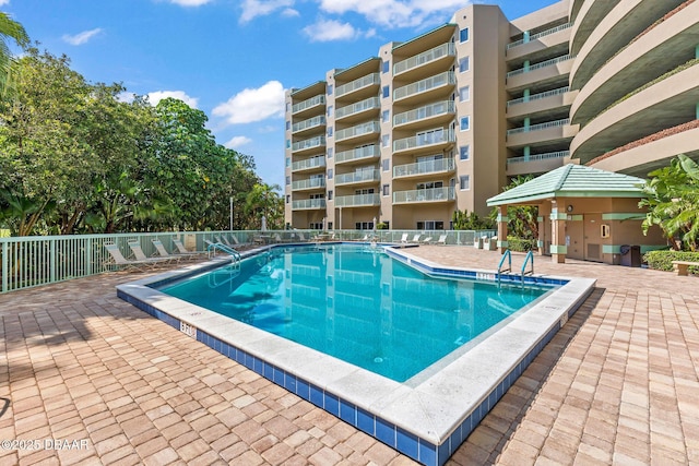community pool with fence and a patio