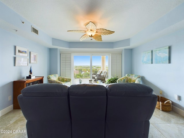 living room with a textured ceiling and ceiling fan