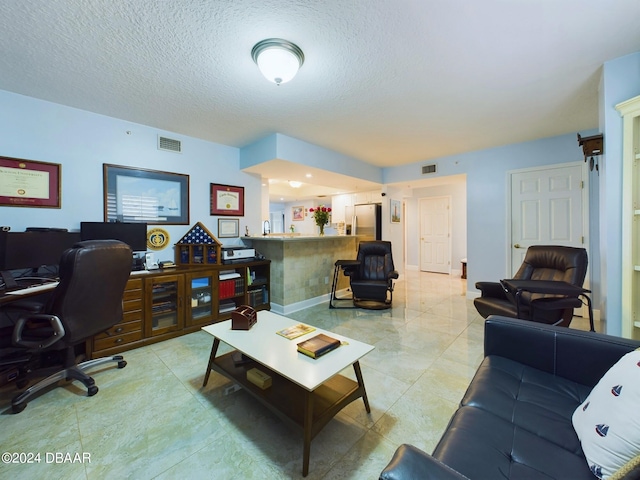 living room with a textured ceiling and light tile patterned floors