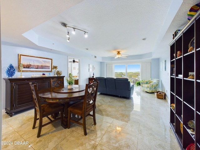 dining space with a textured ceiling and ceiling fan