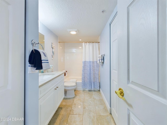 full bathroom with vanity, shower / tub combo with curtain, a textured ceiling, and toilet