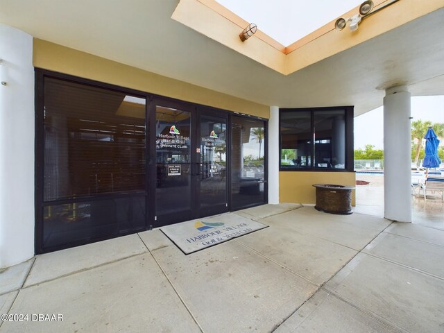 view of exterior entry with a pool, french doors, and a patio area