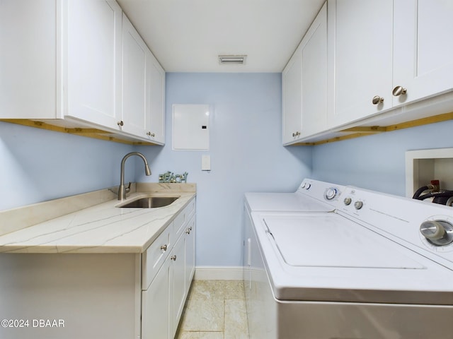 washroom with electric panel, cabinets, sink, and washing machine and clothes dryer