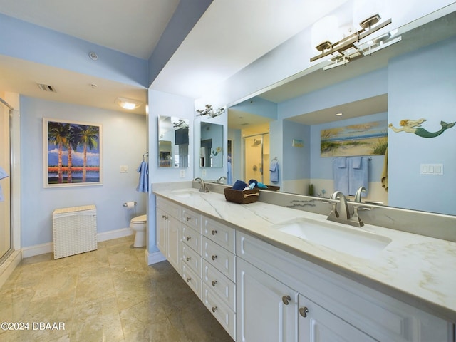 bathroom with vanity, toilet, and a shower with door