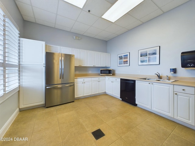 kitchen with plenty of natural light, white cabinetry, a drop ceiling, and stainless steel appliances