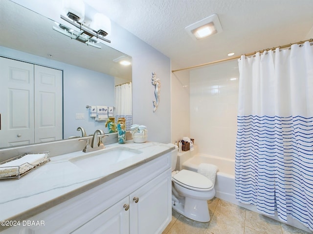 full bathroom featuring tile patterned flooring, a textured ceiling, shower / tub combo with curtain, vanity, and toilet