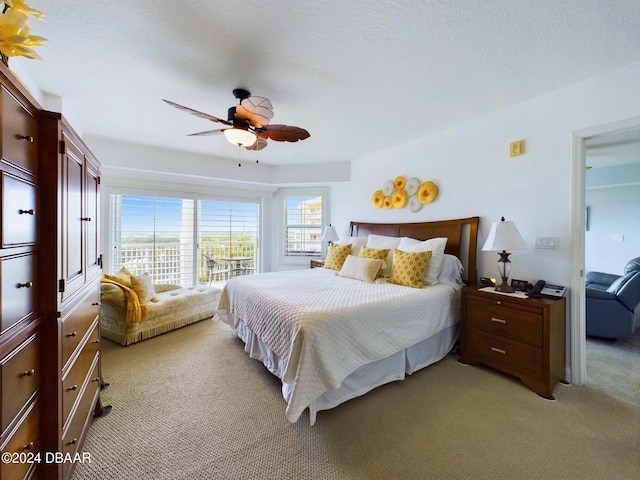 carpeted bedroom with a textured ceiling and ceiling fan