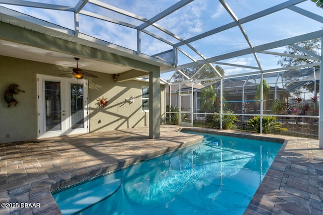 view of swimming pool featuring ceiling fan, glass enclosure, and a patio area