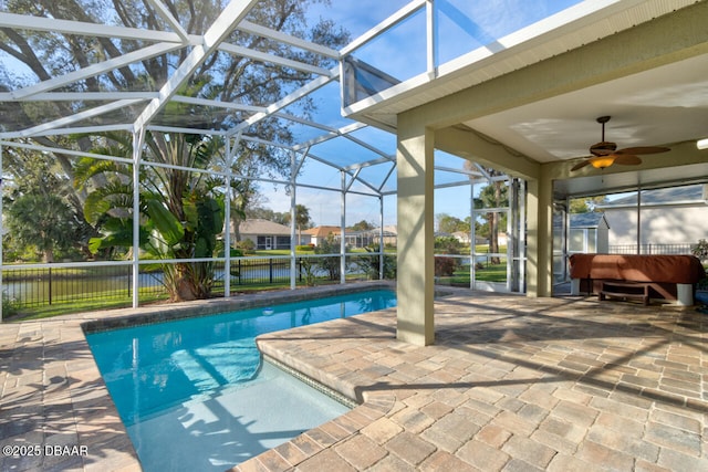 view of swimming pool with a water view, a lanai, ceiling fan, and a patio area