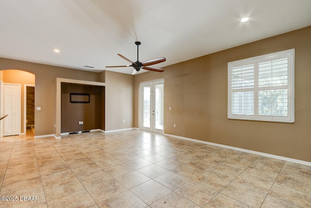 spare room with light tile patterned floors, french doors, and ceiling fan