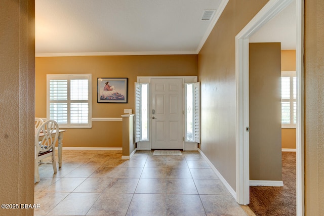 foyer featuring crown molding and light tile patterned floors