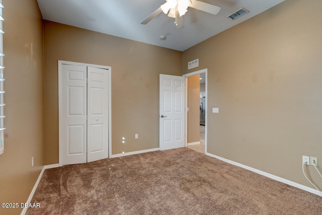 unfurnished bedroom with carpet flooring, ceiling fan, and a closet