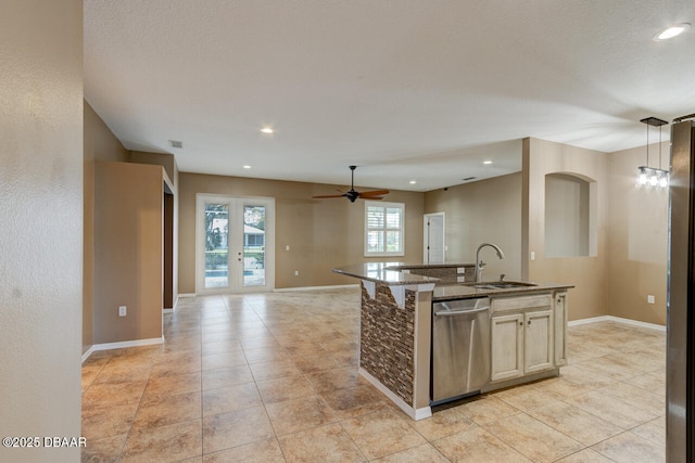 kitchen featuring pendant lighting, sink, ceiling fan, dishwasher, and a center island with sink